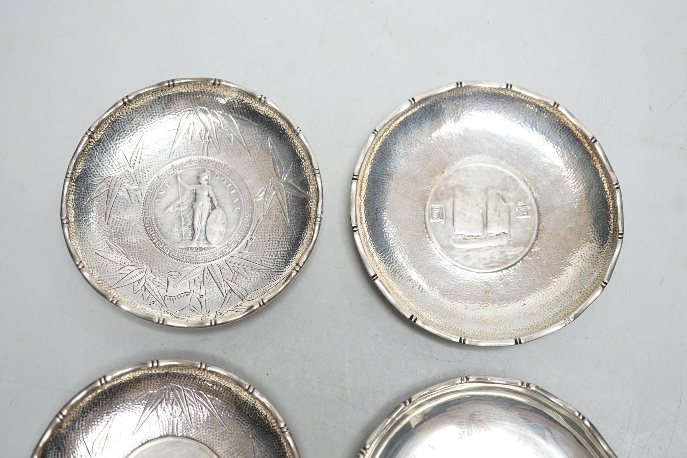 Three Hong Kong white metal mounted Republic of China coin dishes and a similar One Dollar 1930 dish, largest diameter 9cm.